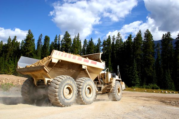 dumptrucks - A-Giant-Dump-Truck-Hauling-Rocks-During-Road-Construction-In-A-Forested-Area